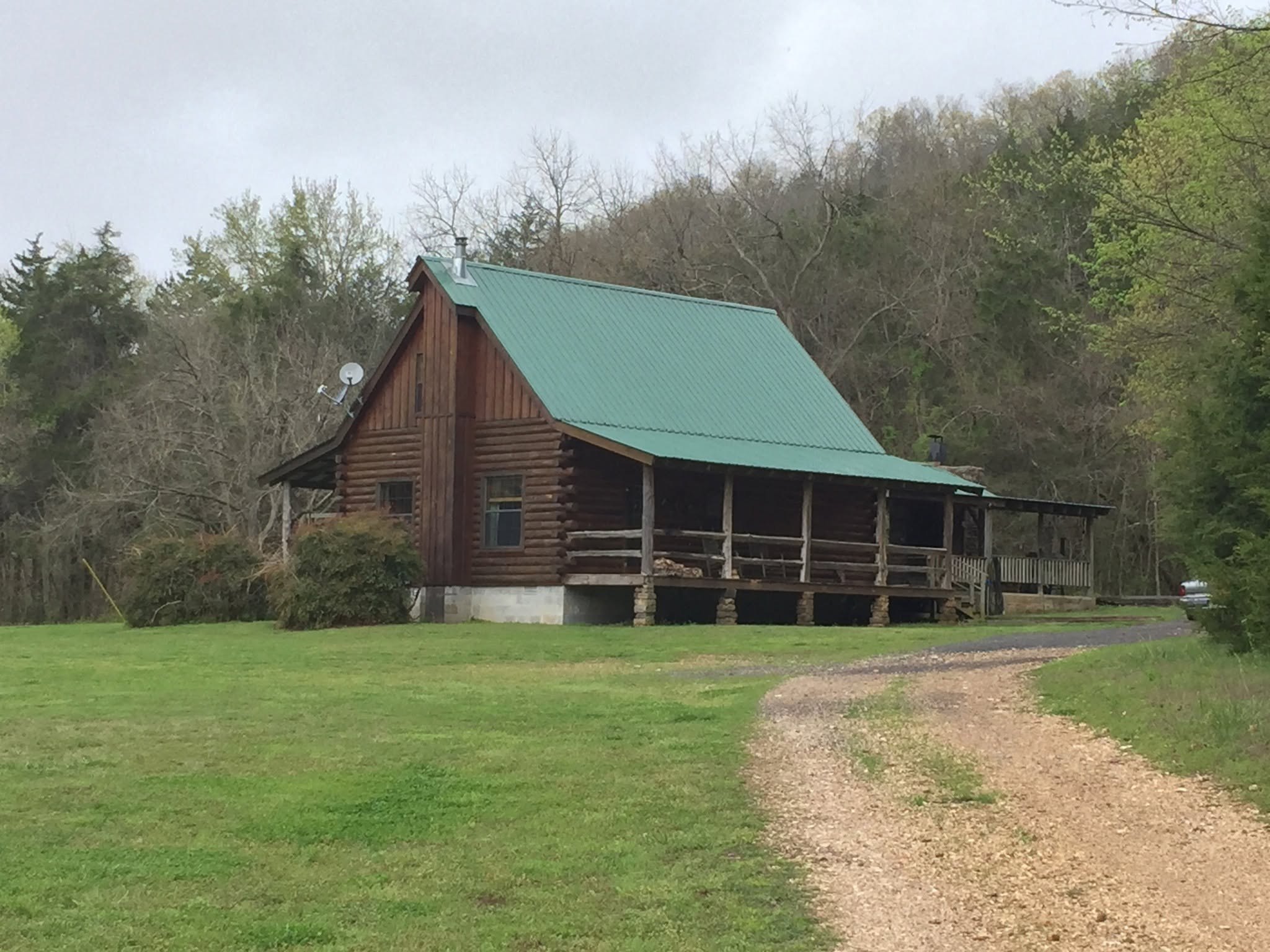 Kindling Trail Cabin in spring beside the gravel drive